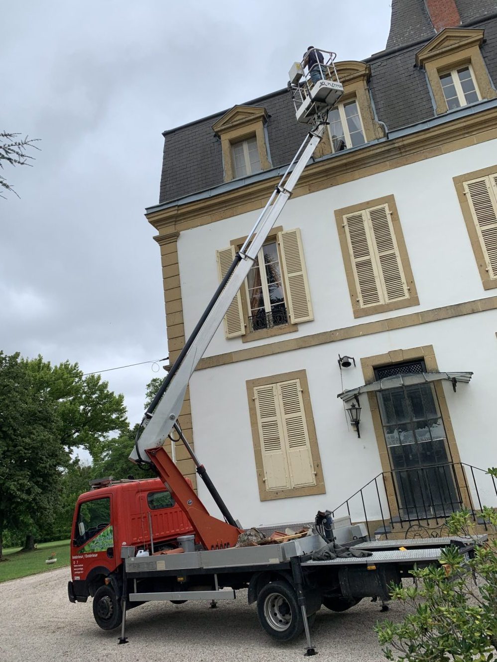 Un camion rouge et blanc est garé devant une maison.
