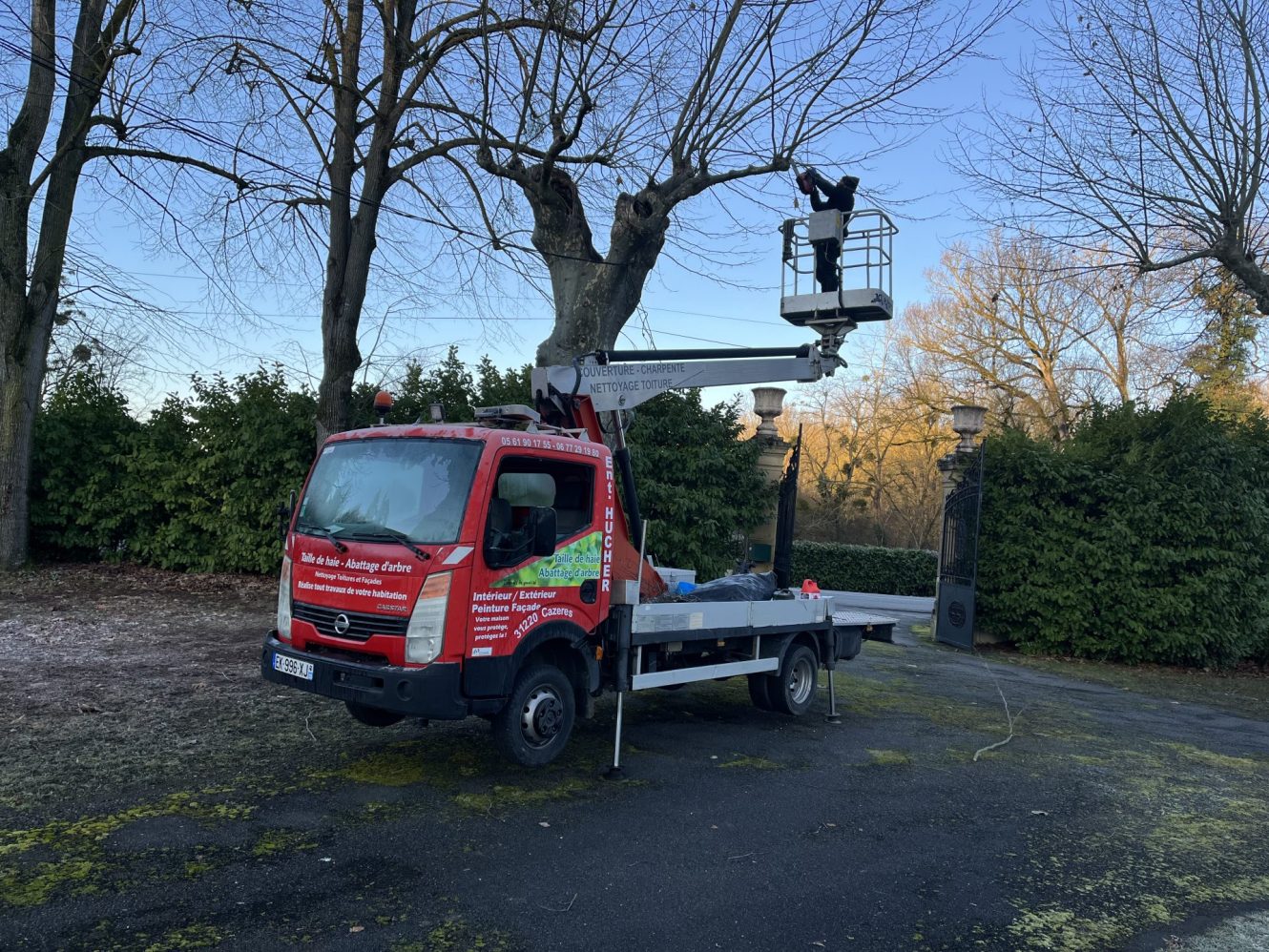 Un camion rouge et blanc stationné devant une maison.