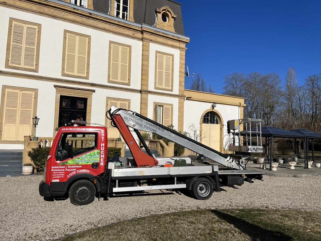Un camion rouge et blanc garé devant un grand bâtiment.